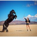 Rearing black horse with girl