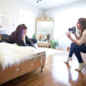 Photographer photographing boudoir session of woman on bed